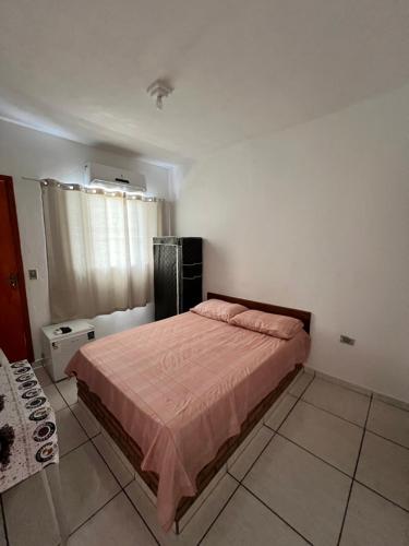 a bedroom with a bed with a pink blanket at Hotel Santa Thereza in Bofete