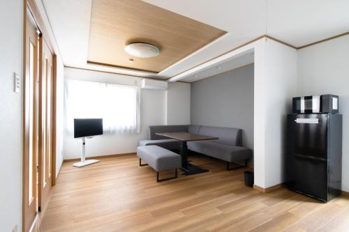 a room with a table and chairs and a television at Casa Stay Kokura 2 - Vacation STAY 27406v in Itabitsu