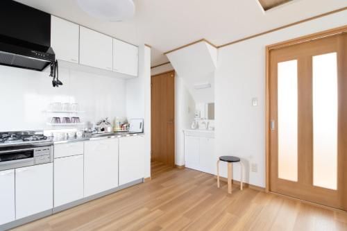 a kitchen with white cabinets and a wooden floor at Casa Stay Kokura 2 - Vacation STAY 27406v in Itabitsu