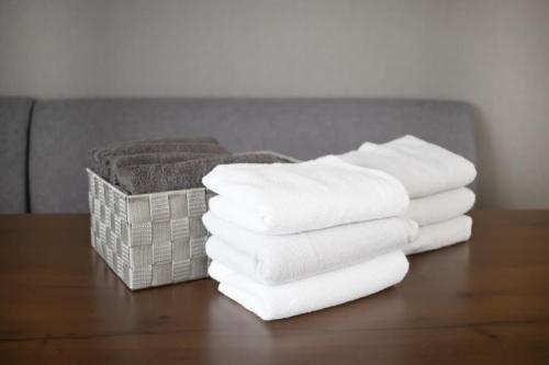 a stack of towels on a table with a basket of towels at Casa Stay Kokura 2 - Vacation STAY 27406v in Itabitsu