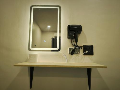 a mirror on a wall with a phone on a shelf at SB The Moon Night Betong in Betong
