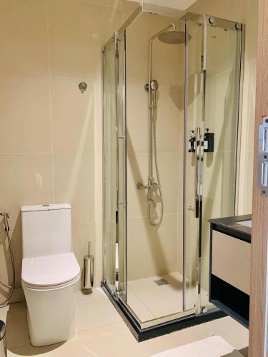 a bathroom with a toilet and a glass shower at New Amaan Hotel in Zanzibar City