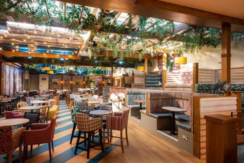 a restaurant with tables and chairs and a bar at 9 Fairway, Hopton Holiday Park - Three bedroom, sleeps 6, kitchen, lounge and dining area - Minimum 3 night breaks in Hopton on Sea