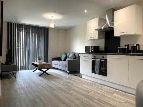a living room with a couch and a kitchen at The Bailey in Manchester