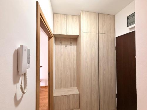 a room with a wooden door and a telephone at Odmor u Podgorici. in Podgorica