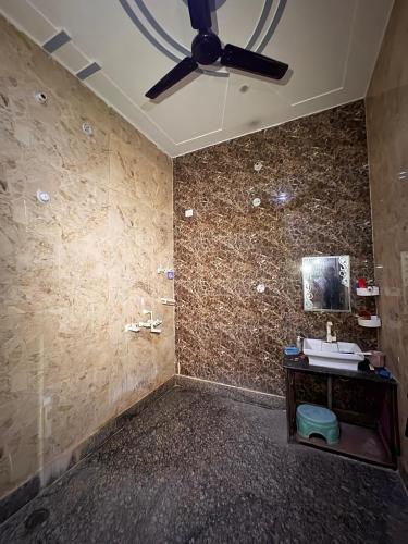 a bathroom with a sink and a ceiling fan at Karshni Kuteer in Mathura