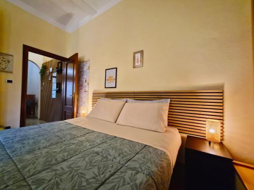 a bedroom with a large bed with a wooden headboard at Quiet Tortellini in Modena