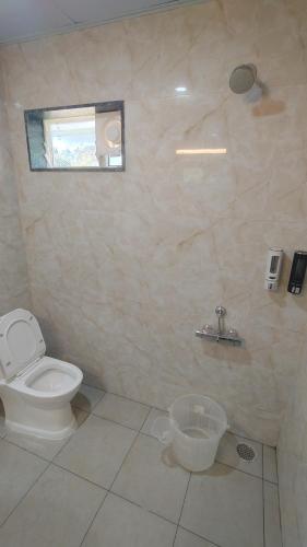 a bathroom with a toilet and a window at COMFORT Inn in Subrahmanya