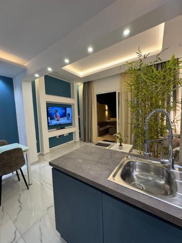 a kitchen with a sink and a tv on a wall at B&S Accommodation Newly Renovated Penthouse 253 in Żejtun