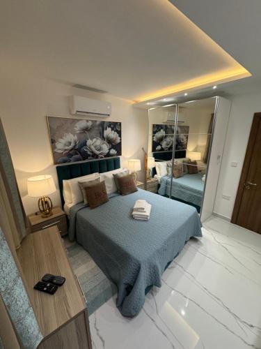 a bedroom with a bed and a large mirror at B&S Accommodation Newly Renovated Penthouse 253 in Żejtun