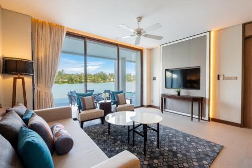 a living room with a couch and a tv at ANGSANA Oceanview Apartments with a privat pool in Laguna area in Bang Tao Beach