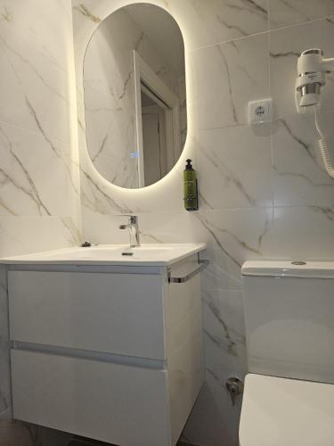 a white bathroom with a sink and a mirror at Hotel Puerta de la Serrania in Lliria