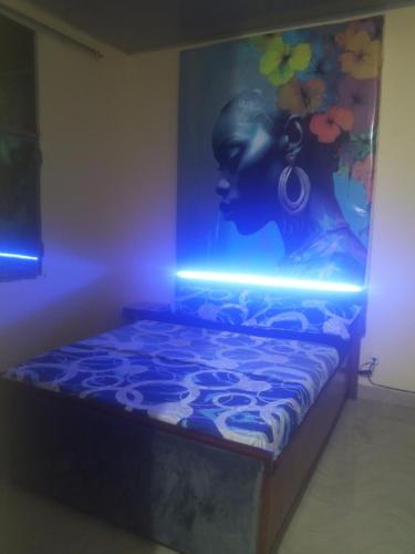 een kamer met een bed met een schilderij aan de muur bij Kiv in Kinshasa