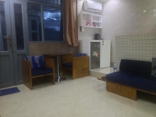 een kamer met stoelen, een tafel en een koelkast bij Kiv in Kinshasa