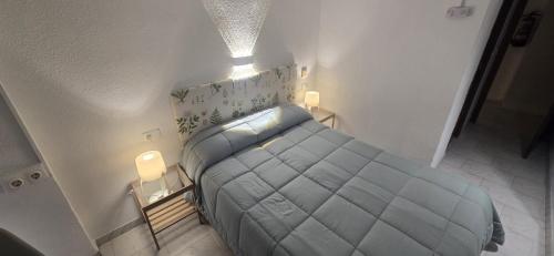 a small bedroom with a bed and two night stands at Hotel Restaurante Salvadora in Villena