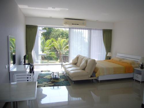 a bedroom with a bed and a couch and a desk at Chic Condominium Unit A303, A306, A307, A308, A406 in Karon Beach