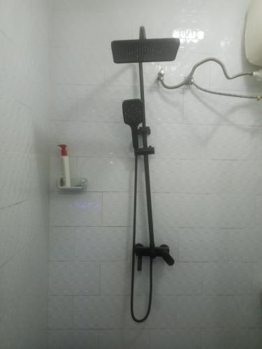 een douche met een föhn in een badkamer bij Kiv in Kinshasa