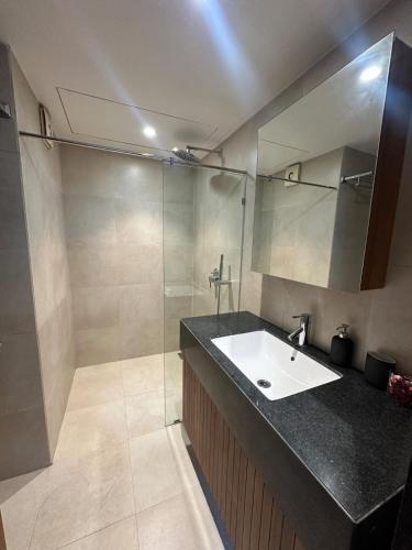 a bathroom with a sink and a shower at Skyline Serenia 23rd floor in Dehu Road