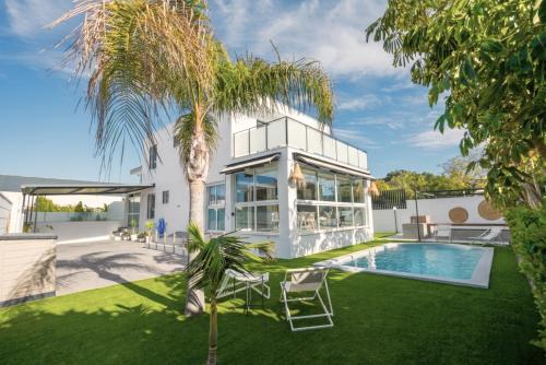 a house with a pool and a palm tree at Casa Alegra Pool & Spa in Gran Alacant