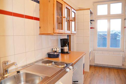 a kitchen with a sink and a counter top at Appartementhaus Seestern in Borkum