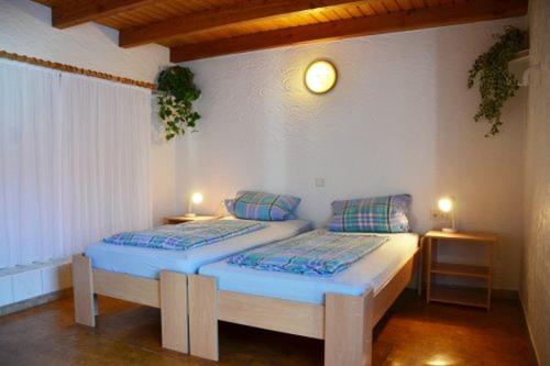 two twin beds in a room with two lamps at Appartementhaus Seestern in Borkum