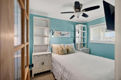 a bedroom with a white bed with a ceiling fan at SC304A: 304A Sea Cabin in Isle of Palms