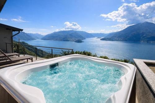 a hot tub with a view of a lake at Splend'Or - A Real Paradise in Perledo