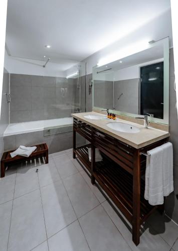 ein Badezimmer mit einem großen Waschbecken und einer Badewanne in der Unterkunft Hôtel du Golf Mohammedia in Mohammedia