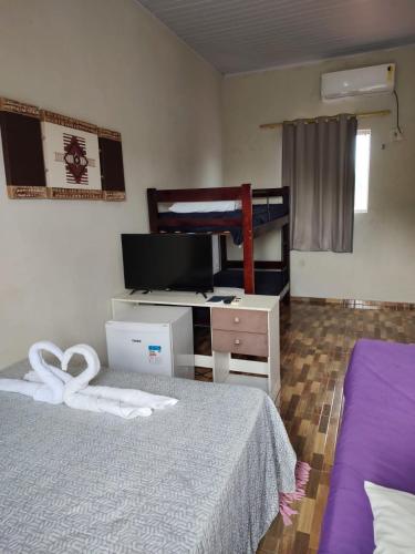 a bedroom with a bed and a desk and a bunk bed at Pousada Riocabana in Barreirinhas