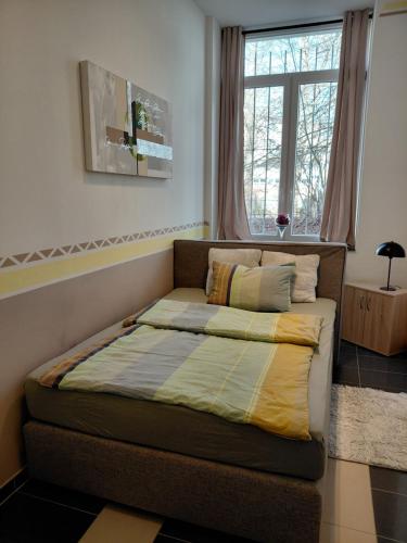 a bed sitting in a room with a window at Ferienwohnung CityImmo in Gotha