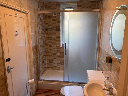 a bathroom with a shower and a toilet and a sink at Netherby Guest House Edinburgh in Edinburgh