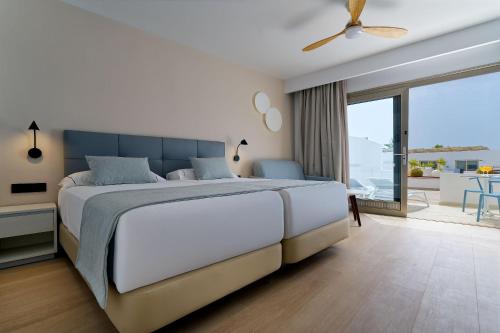 a bedroom with a large bed and a balcony at Hotel Las Costas in Puerto del Carmen