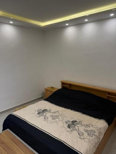 a bed in a room with a white wall at Salam Apartments in Amman