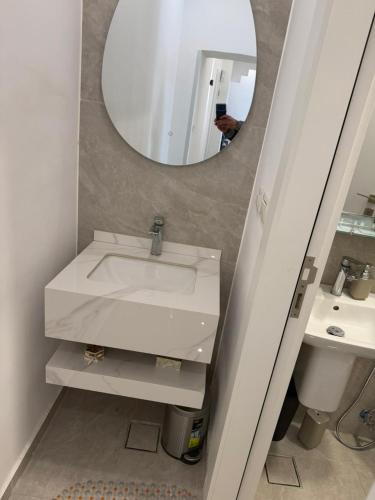 a bathroom with a white sink and a mirror at Salam Apartments in Amman