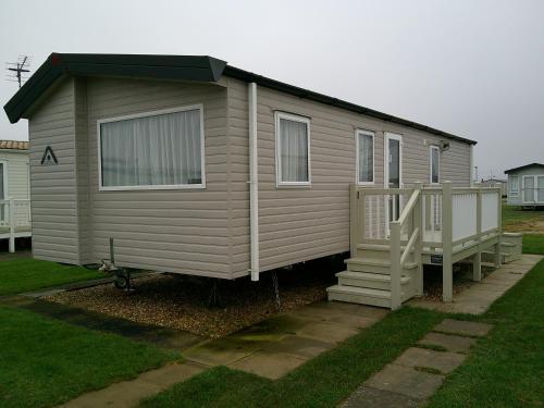 a small house with a porch and a staircase at Kingfisher Festival 6 Berth Central Heated Close to site entrance in Ingoldmells