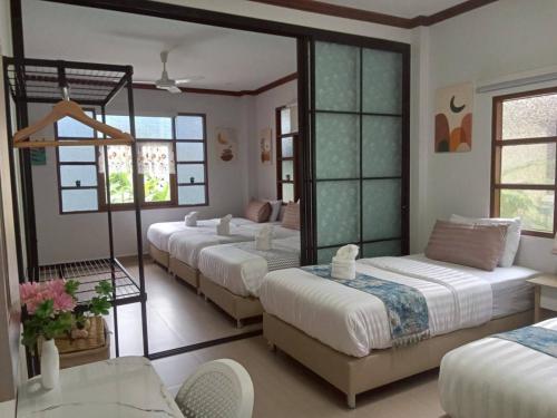 a room with four beds and a mirror at Celine Pool Villa Cha-Am in Cha Am
