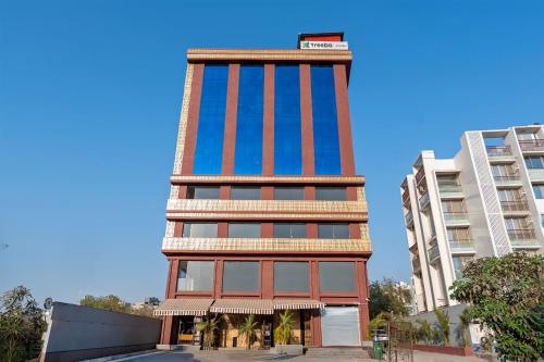 a tall building with red and blue windows at Treebo Arizona in Gandhinagar