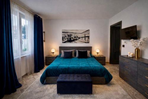 a bedroom with a large bed with a blue bedspread at Lore Sole in Caluso