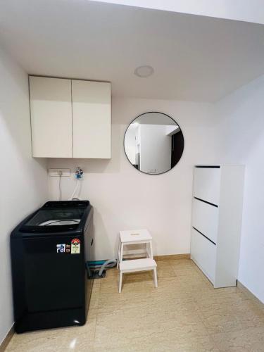 a kitchen with a black refrigerator and a small stool at Serene white studio - 2nd floor in Dehu Road