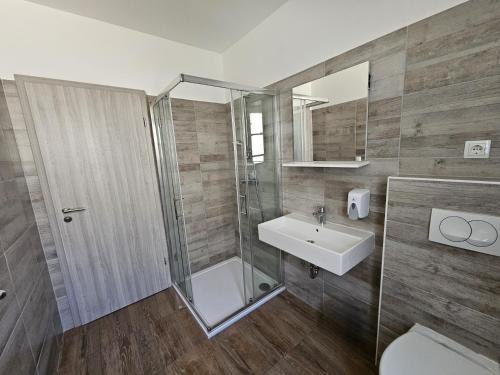 a bathroom with a shower and a sink and a toilet at Great Mountain B&B Platak in Platak