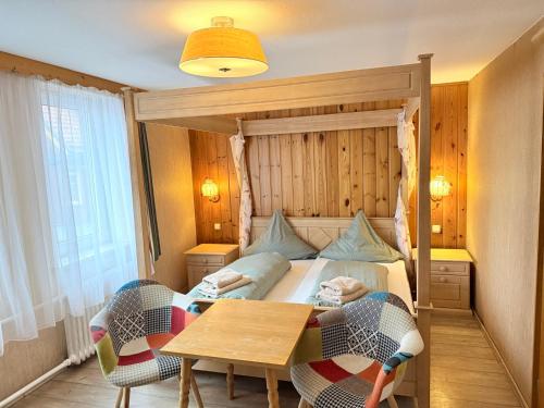 a bedroom with a bed and a table with chairs at Hotel Zur Erholung in Braunlage