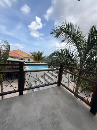a balcony with a view of a swimming pool at Apartment Jayhden or Chloé New Stay & Pool with Ocean View Curaçao in Grote Berg