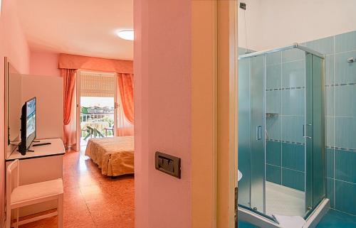 a room with a bathroom with a shower and a bedroom at Hotel Lido in Marina di Massa