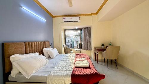 a bedroom with a bed and a table and a window at Spacious 2BHK flat in new panvel in Navi Mumbai