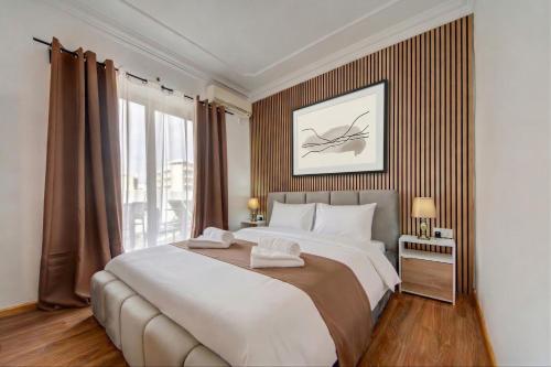 a bedroom with a large bed and a large window at Sliema Seaview 4BD Apartments & Penthouse with Jacuzzi in Sliema