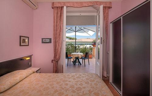 a bedroom with a bed and a door leading to a patio at Hotel Lido in Marina di Massa