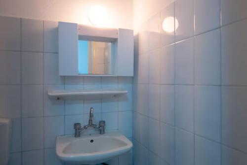 a white bathroom with a sink and a mirror at Anemone Masouri in Masouri