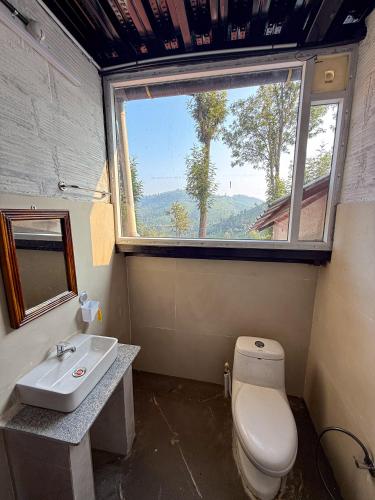 a bathroom with a toilet and a sink and a window at Mad & Nomad Backpackers Hostel in Coonoor