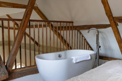 a white bath tub in a room with a staircase at Hintlesham Hall Hotel in Ipswich