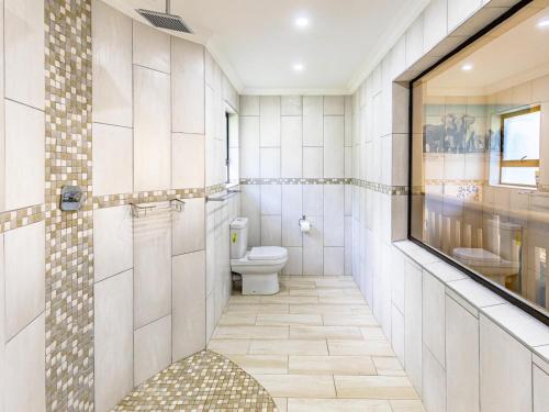 a bathroom with a toilet and a mirror at Villa Alba in Margate